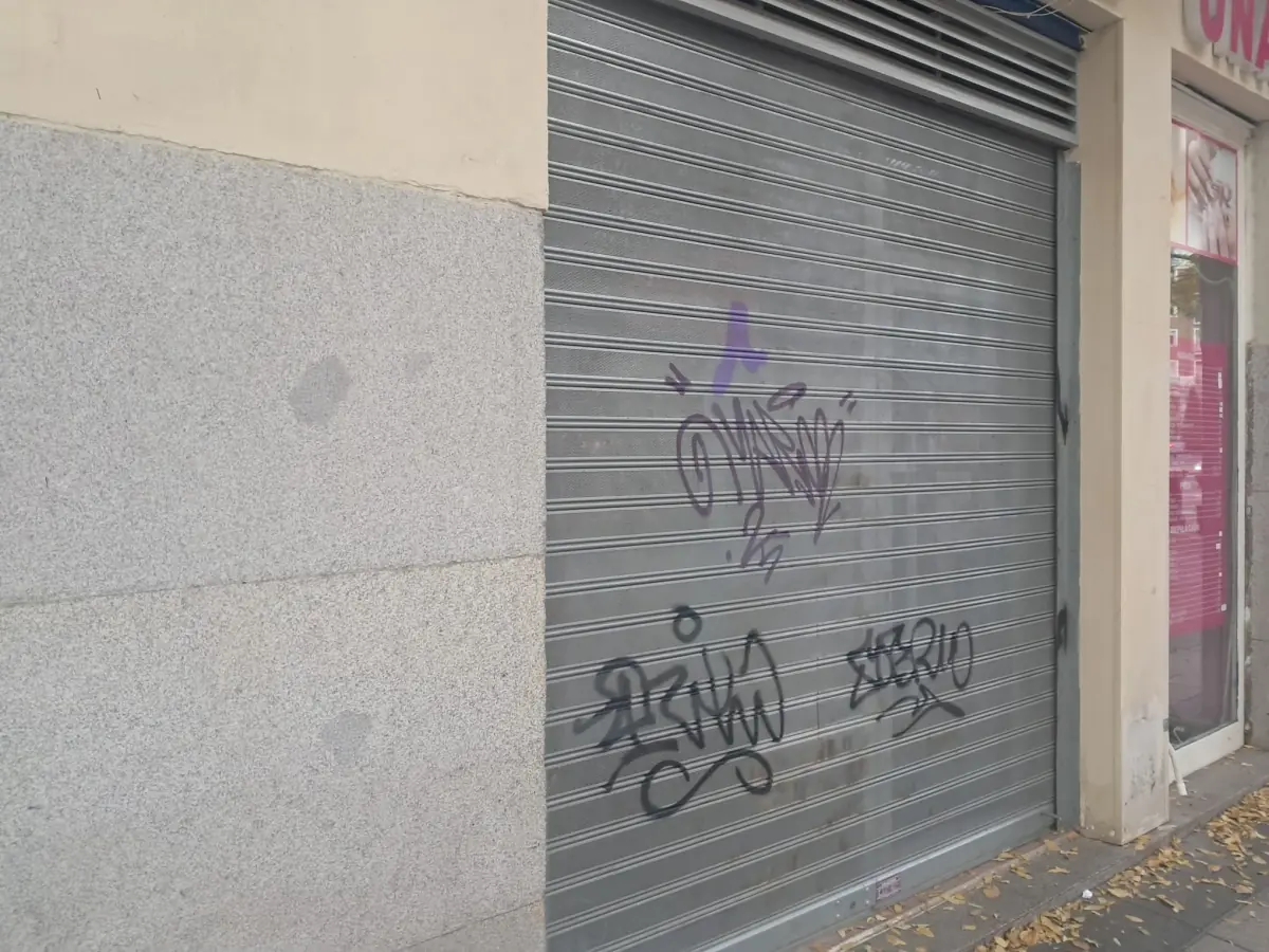 Persiana metálica microperforada bajada en un local comercial de Barcelona