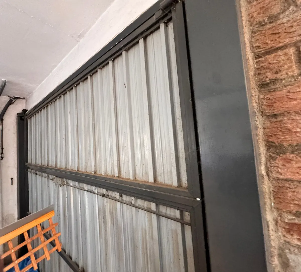 Puerta basculante metálica de garaje antes de sustituirla por una enrollable